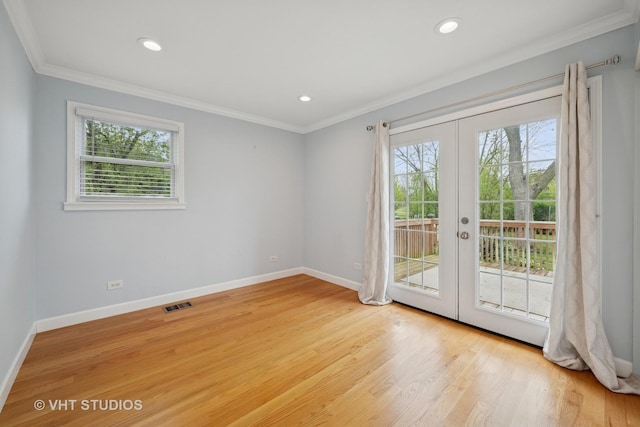 spare room with french doors, light wood-type flooring, visible vents, crown molding, and baseboards
