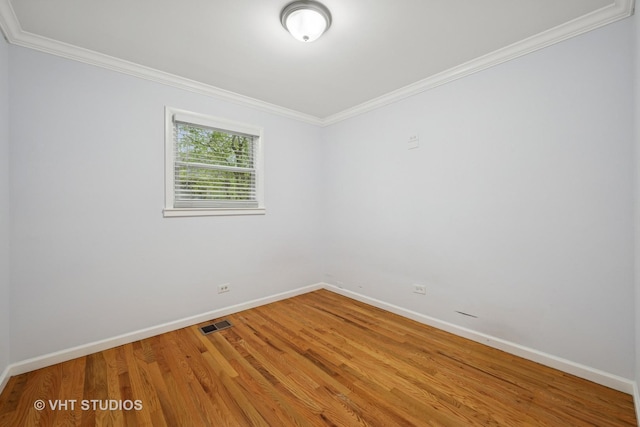 unfurnished room featuring crown molding, baseboards, visible vents, and wood finished floors