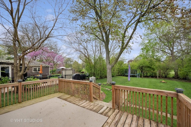 wooden deck with a yard, an outbuilding, and a shed