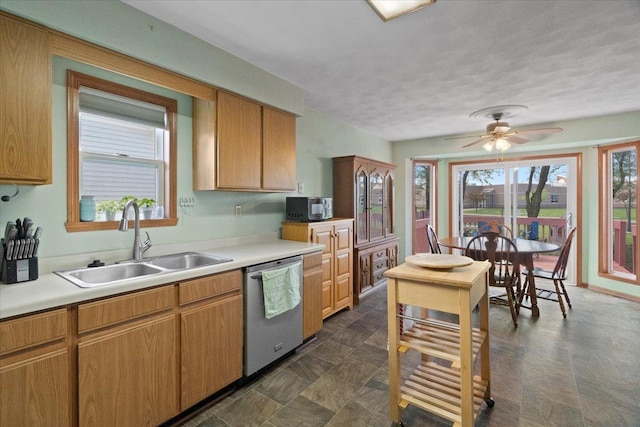 kitchen featuring a sink, black microwave, light countertops, a ceiling fan, and stainless steel dishwasher