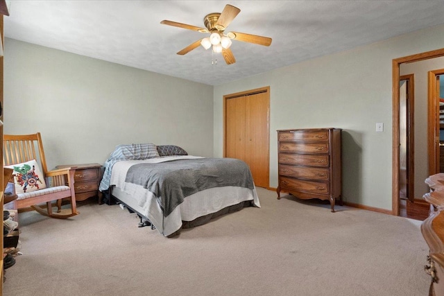 carpeted bedroom featuring a ceiling fan, baseboards, and a closet