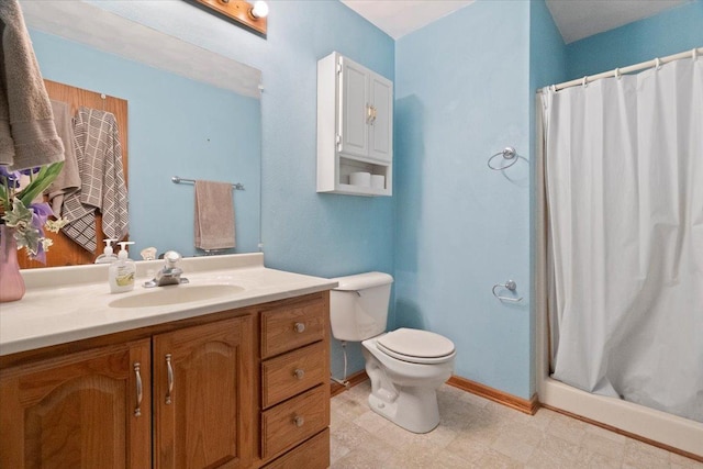 bathroom with a shower stall, baseboards, vanity, and toilet