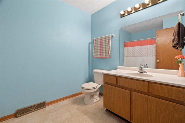 bathroom featuring toilet, vanity, visible vents, tile patterned floors, and baseboards