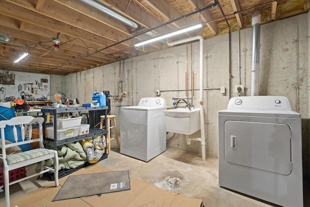 laundry area featuring laundry area, washing machine and dryer, and a sink