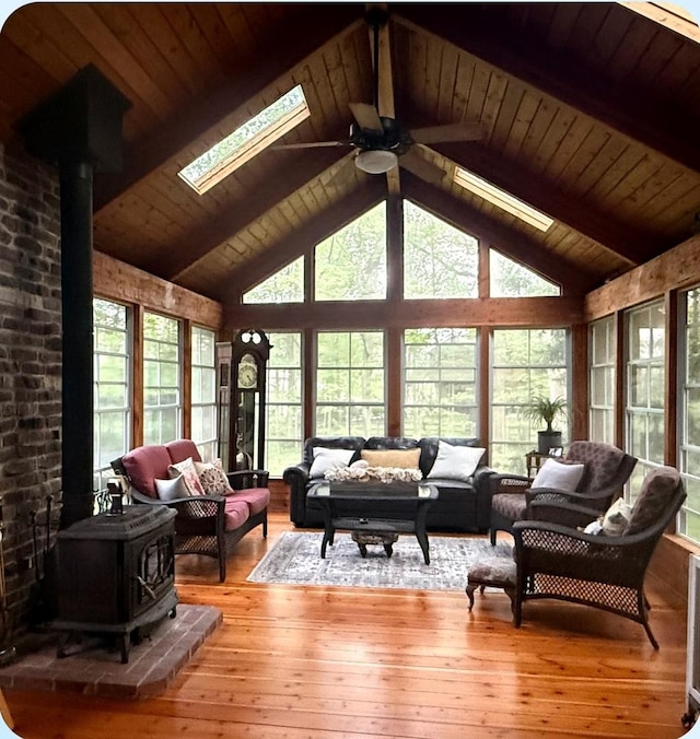 6N241 Roselle Rd, Roselle, IL 60172 - living room featuring a wood stove, a ceiling fan, a skylight, healthy amount of natural light, and beamed ceiling