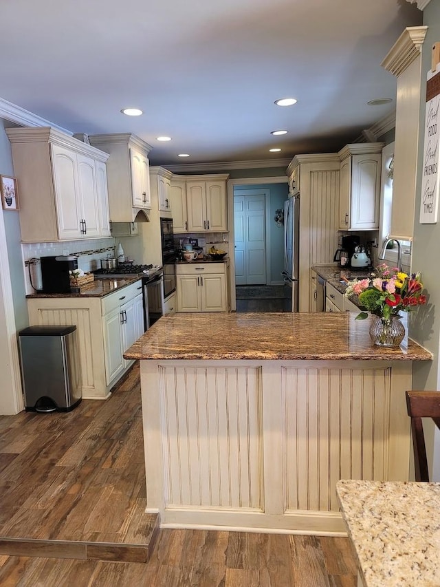 6N241 Roselle Rd, Roselle, IL 60172 - kitchen with freestanding refrigerator, a peninsula, decorative backsplash, gas stove, and dark wood finished floors