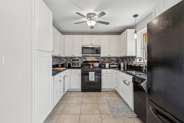 kitchen featuring black appliances, a sink, decorative backsplash, light tile patterned floors, and dark countertops
