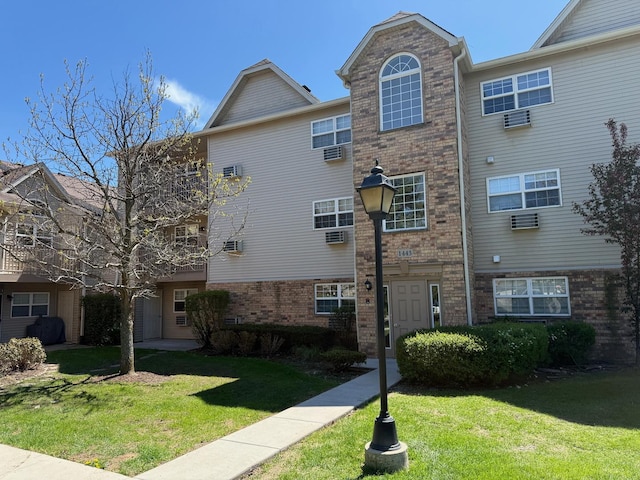 1443 Spring Brook Ct Unit 1B, Round Lake Beach, IL 60073 - view of side of home featuring brick siding and a lawn