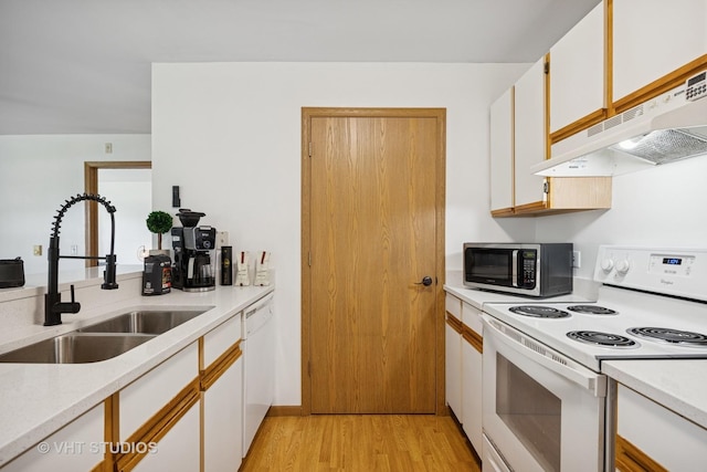 1443 Spring Brook Ct Unit 1B, Round Lake Beach, IL 60073 - kitchen with white appliances, under cabinet range hood, a sink, light countertops, and light wood finished floors