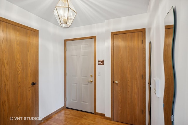 1443 Spring Brook Ct Unit 1B, Round Lake Beach, IL 60073 - corridor with light wood-style flooring, a chandelier, and baseboards