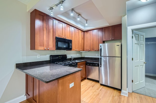 2241 N Lincoln Ave Unit 1A, Chicago, IL 60614 - kitchen featuring black appliances, a peninsula, a sink, light wood-style floors, and track lighting