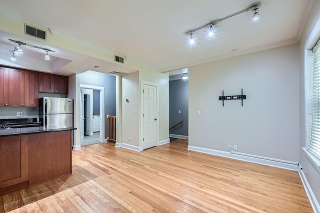 2241 N Lincoln Ave Unit 1A, Chicago, IL 60614 - kitchen featuring rail lighting, dark countertops, freestanding refrigerator, light wood-style flooring, and ornamental molding
