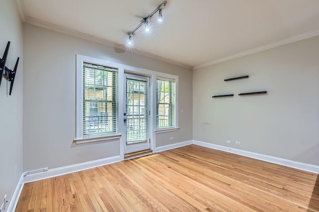 2241 N Lincoln Ave Unit 1A, Chicago, IL 60614 - spare room featuring rail lighting, light wood-type flooring, crown molding, and baseboards