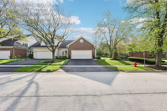 316 Spring Creek Cir, Schaumburg, IL 60173 - traditional-style house featuring an attached garage, a front yard, brick siding, and asphalt driveway