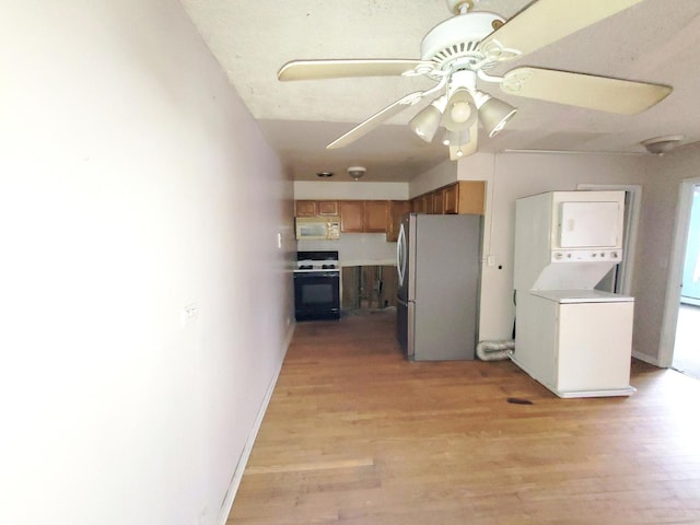 1227 S Harlem Ave Unit 208, Berwyn, IL 60402 - kitchen featuring white microwave, freestanding refrigerator, stacked washer / drying machine, light wood-style flooring, and stove