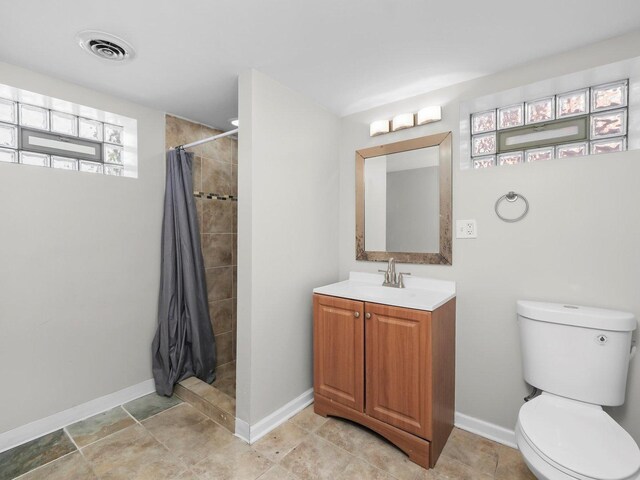 417 Oglesby Ave, Calumet City, IL 60409 - full bathroom featuring toilet, tiled shower, visible vents, baseboards, and vanity