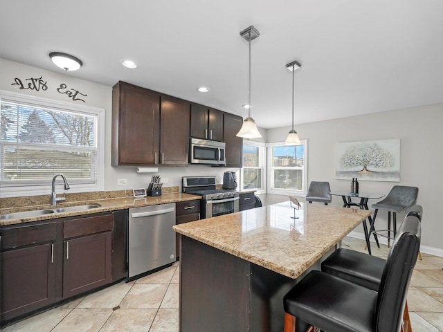 417 Oglesby Ave, Calumet City, IL 60409 - kitchen featuring a wealth of natural light, stainless steel appliances, a kitchen breakfast bar, and a sink