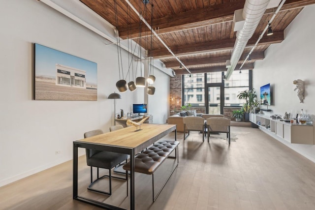 dining space with wooden ceiling, wood finished floors, beamed ceiling, and baseboards