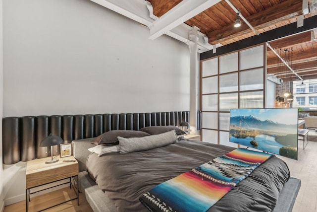 bedroom featuring wooden ceiling, beam ceiling, and wood finished floors