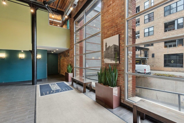 common area with a towering ceiling and brick wall