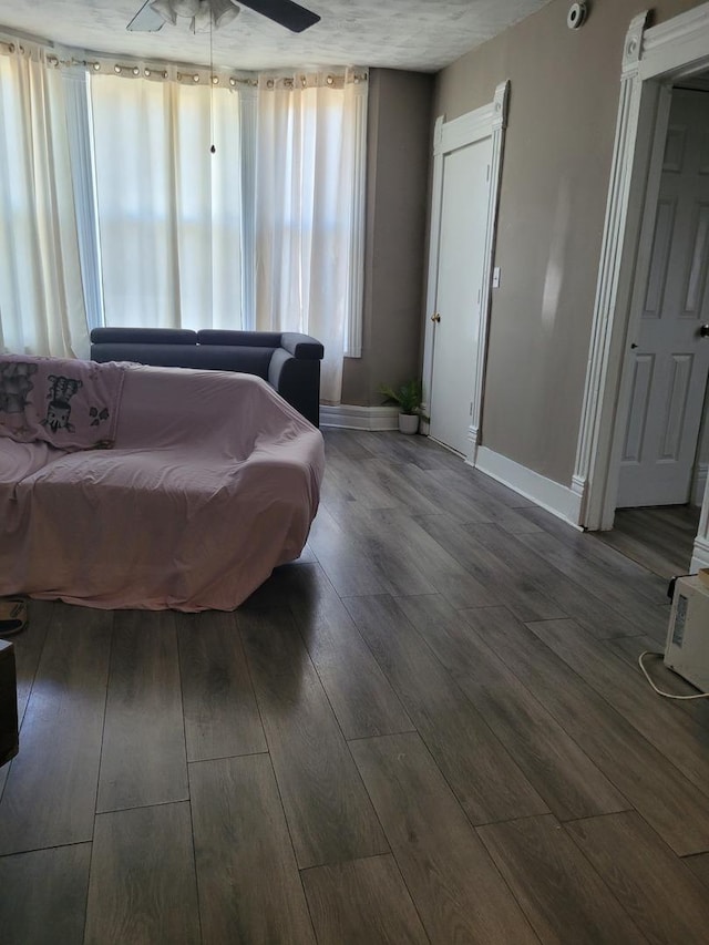 bedroom featuring wood finished floors, baseboards, and multiple windows