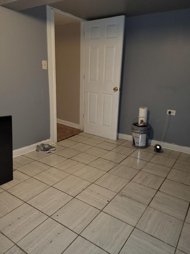 empty room featuring light tile patterned floors and baseboards
