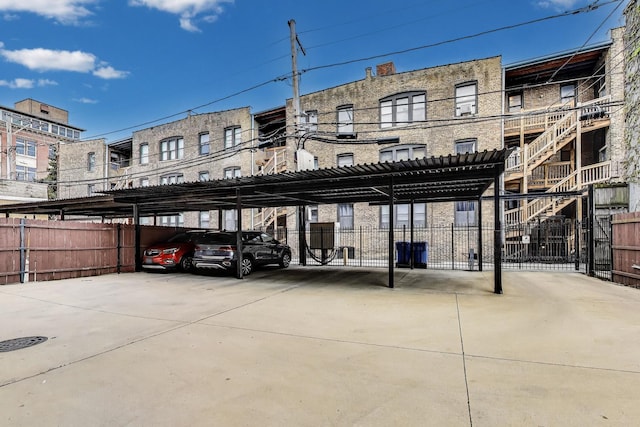 covered parking lot featuring fence
