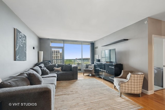 living area featuring visible vents, wood finished floors, and expansive windows