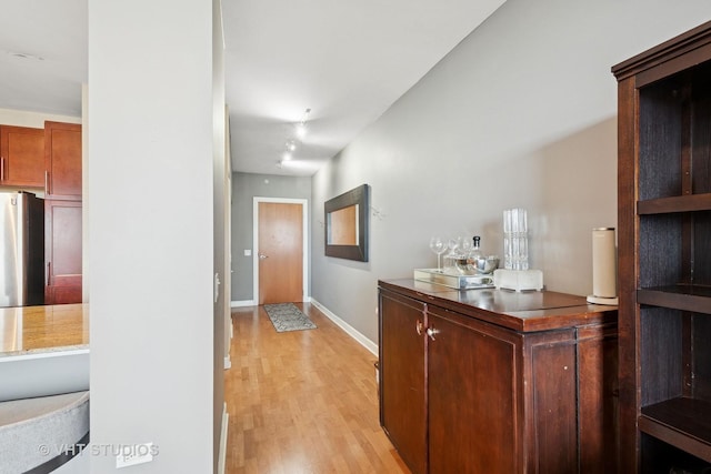 hallway featuring baseboards and light wood finished floors