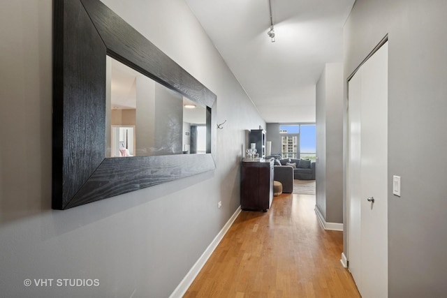 hall with baseboards and wood finished floors