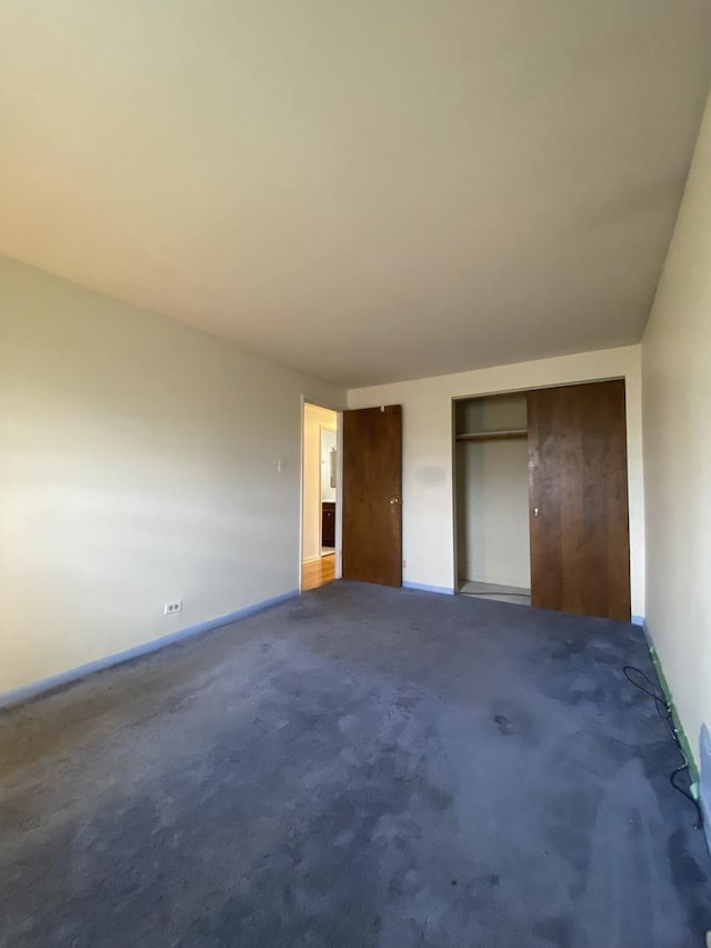unfurnished bedroom with baseboards, carpet floors, and multiple closets