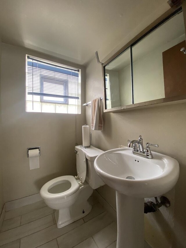 half bathroom featuring toilet and tile patterned flooring