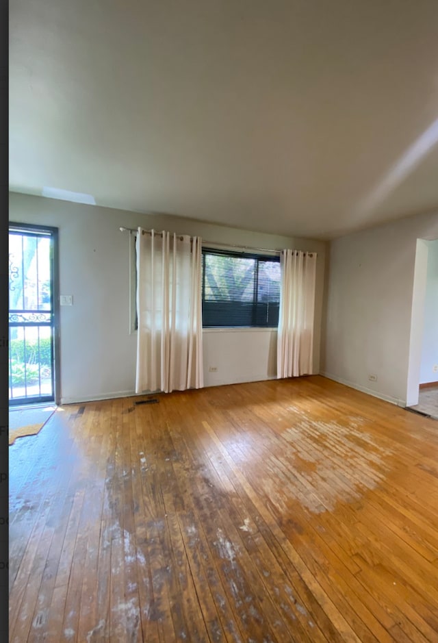 spare room with hardwood / wood-style floors and baseboards