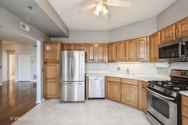 3115 Town Square Dr Unit 303, Rolling Meadows, IL 60008 - kitchen featuring stainless steel appliances, a ceiling fan, light countertops, a sink, and backsplash