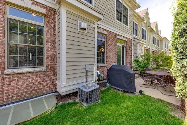 893 S Plum Grove Rd, Palatine, IL 60067 - exterior space with brick siding, a patio, cooling unit, and a lawn