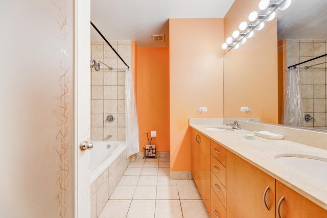 bathroom with tiled shower / bath, tile patterned floors, visible vents, and a sink