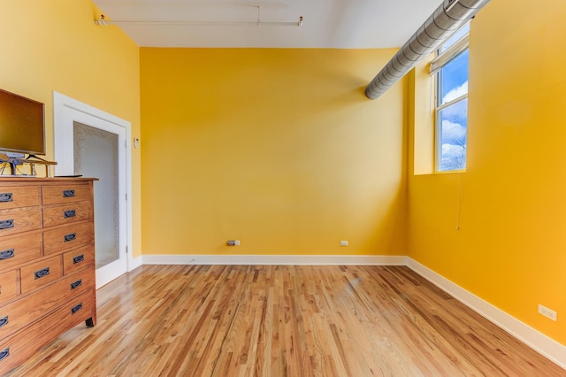 unfurnished room featuring baseboards and light wood-style floors