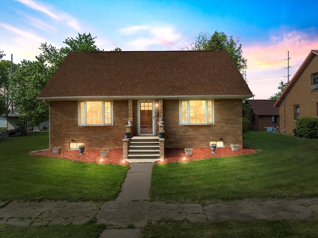 304 W Elm St, Fairbury, IL 61739 - view of front facade with brick siding, a lawn, and roof with shingles