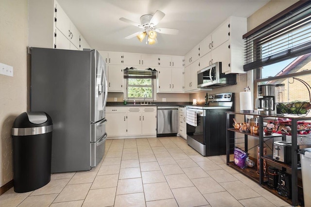 304 W Elm St, Fairbury, IL 61739 - kitchen featuring appliances with stainless steel finishes, a sink, a ceiling fan, dark countertops, and light tile patterned flooring