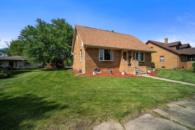 304 W Elm St, Fairbury, IL 61739 - rear view of house featuring brick siding, a yard, and a shingled roof