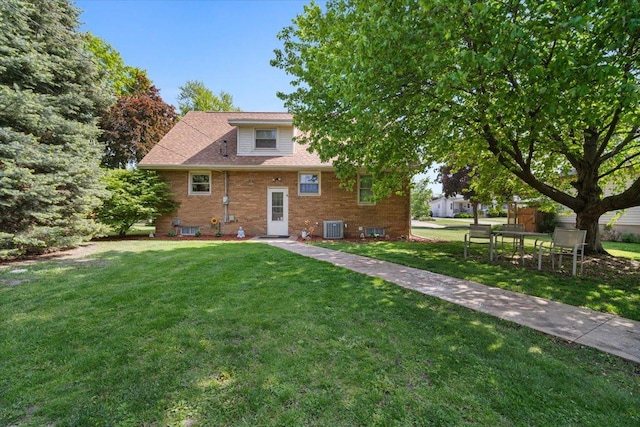 304 W Elm St, Fairbury, IL 61739 - rear view of house with cooling unit, a yard, and brick siding