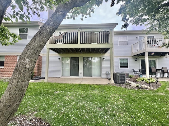 rear view of property featuring a yard, a patio, and cooling unit