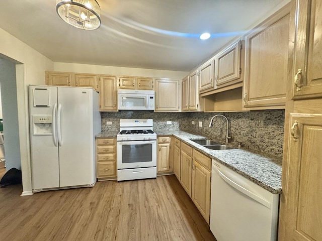kitchen featuring white appliances, light brown cabinetry, light wood-style flooring, and a sink