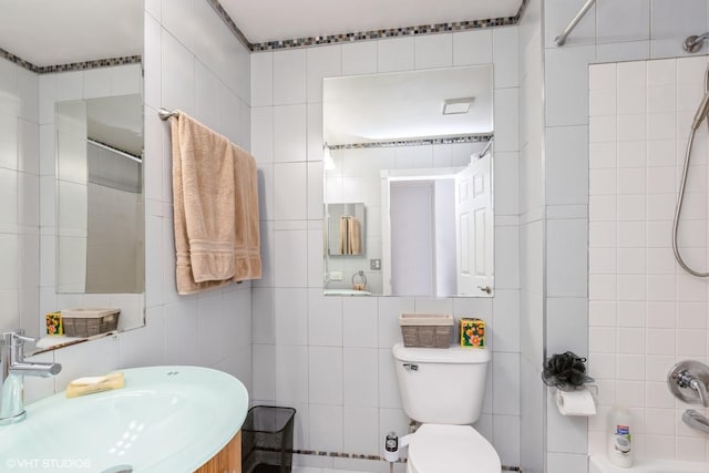 full bathroom with tile walls, a sink, shower / bathtub combination, and toilet