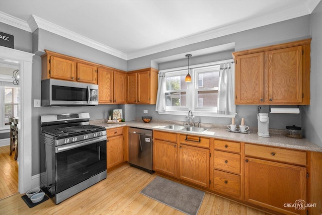 759 E Wilson St, Batavia, IL 60510 - kitchen featuring stainless steel appliances, a sink, light wood-style floors, crown molding, and light countertops