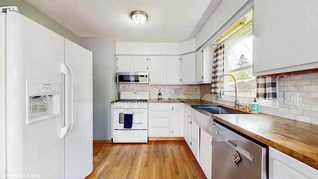 121 Northern Ter, Island Lake, IL 60042 - kitchen with appliances with stainless steel finishes, a sink, light wood-style flooring, decorative backsplash, and white cabinets