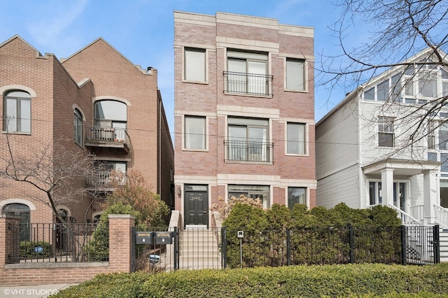 view of front of home featuring brick siding and a fenced front yard