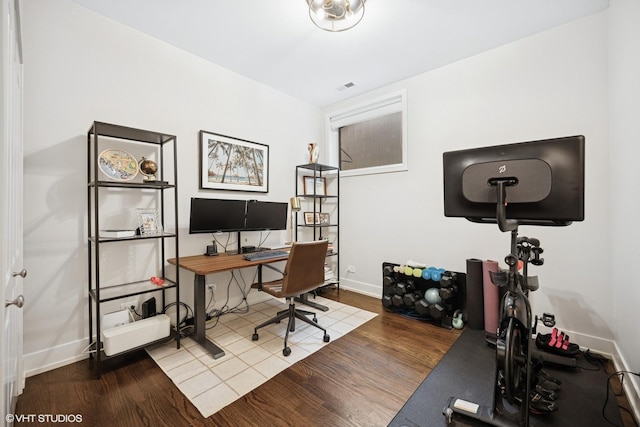 home office with baseboards and wood finished floors