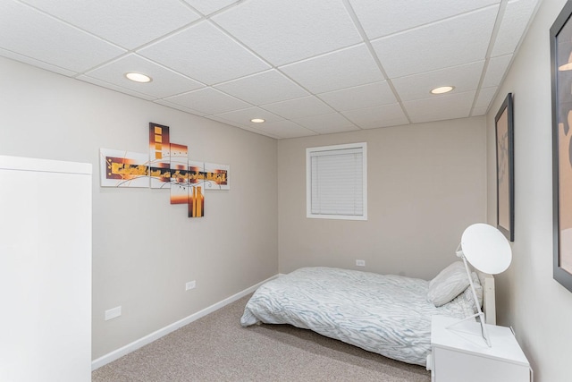carpeted bedroom featuring baseboards, a drop ceiling, and recessed lighting
