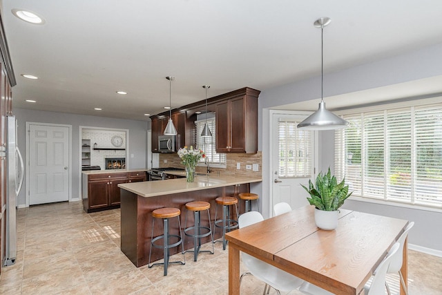 kitchen with appliances with stainless steel finishes, plenty of natural light, a sink, a peninsula, and recessed lighting